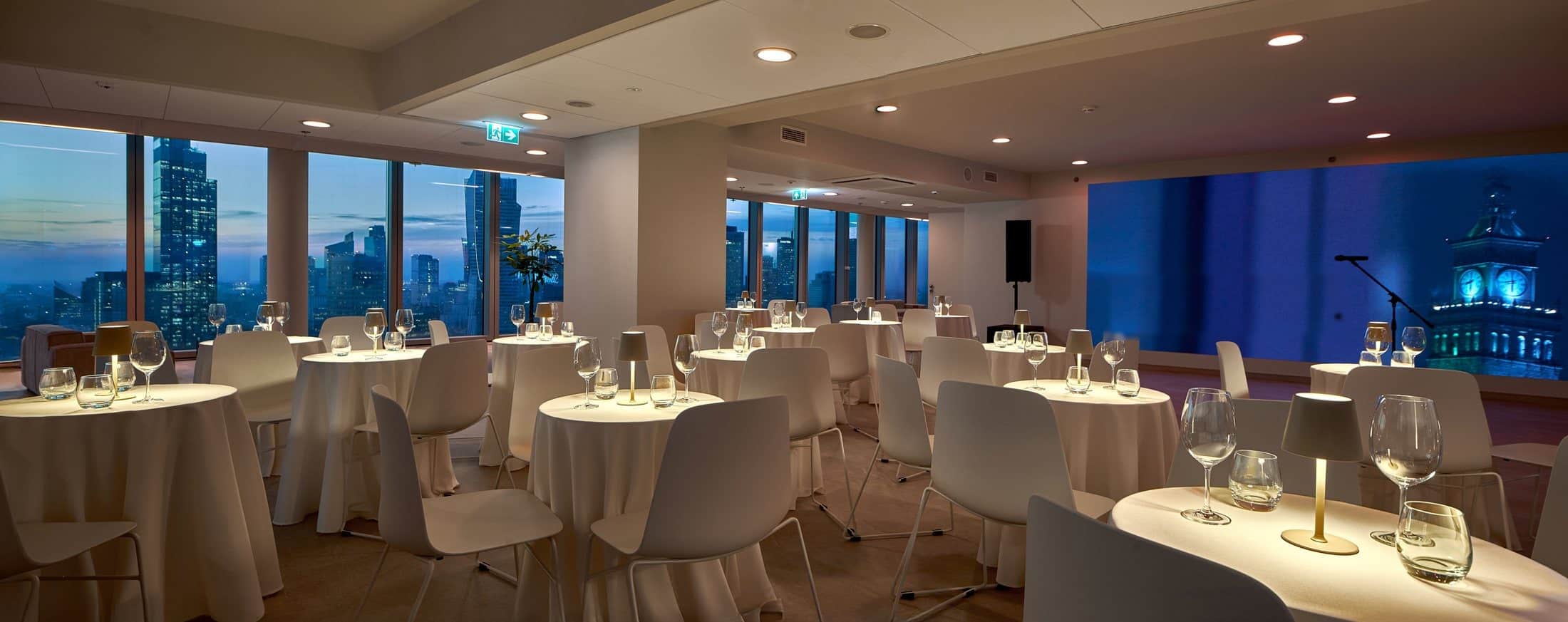 Sala bankietowa Warszawa — niebieski ekran sceniczny i wieczorna panorama miasta