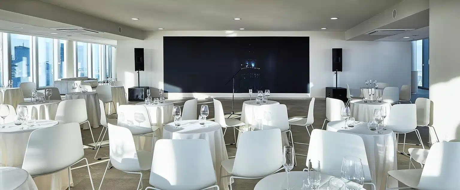 Dziewięć okrągłych stołów na 90 osób i ekran LED wieczorem, Widok Towers